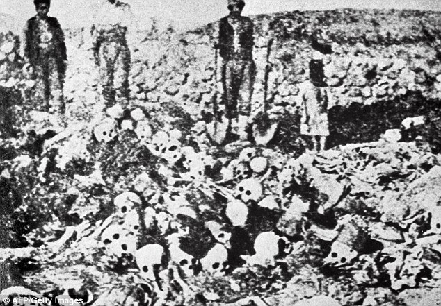 Never forget: An undated photograph shows men standing behind a mass grave containing the remains of Armenian victims slaughtered by the Ottoman Turks during the 1915 genocide